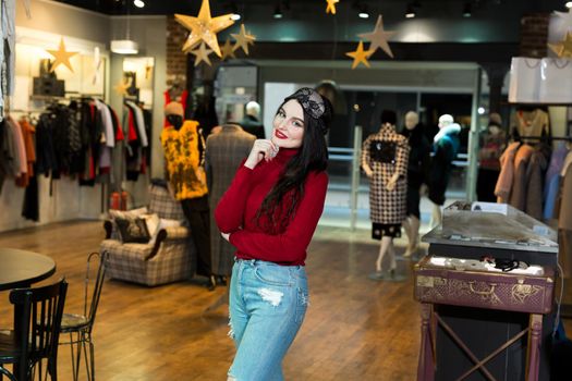 Portrait of model woman in sleeping mask. Pretty young woman happily smiling and posing in clothing store