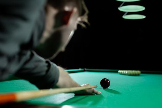 Rear view of man aiming the billiard ball with cue