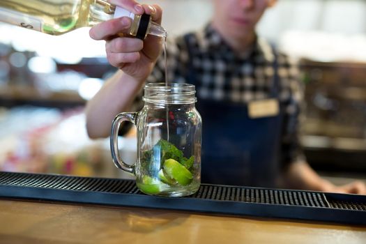 Barman makes a cocktail on the bar in the restaurant.