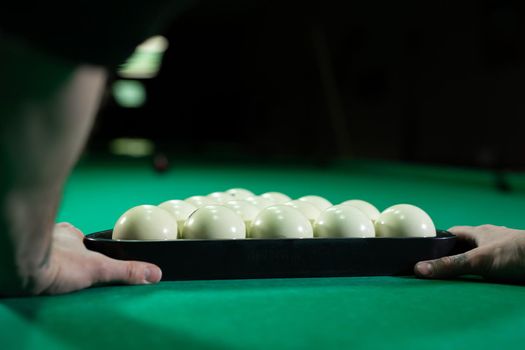 Triangle of billiard balls. A man getting ready to start a game of billiards