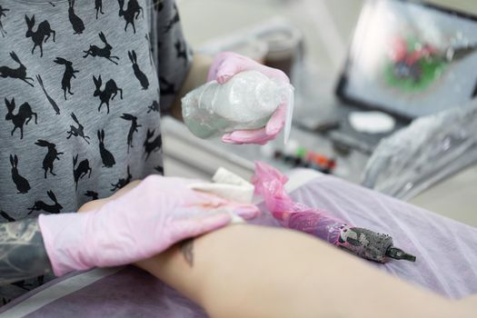 Tattoo master treats the skin after application