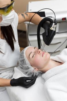 Hair removal cosmetology procedure from a therapist at cosmetic beauty spa clinic. Laser epilation and cosmetology