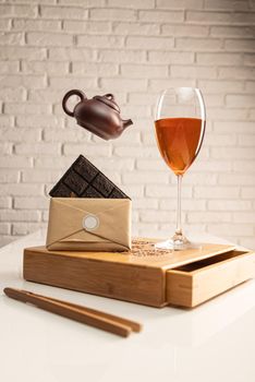 tea table with tea and a wine glass in which Sheng Pu'er tea is poured to demonstrate the color