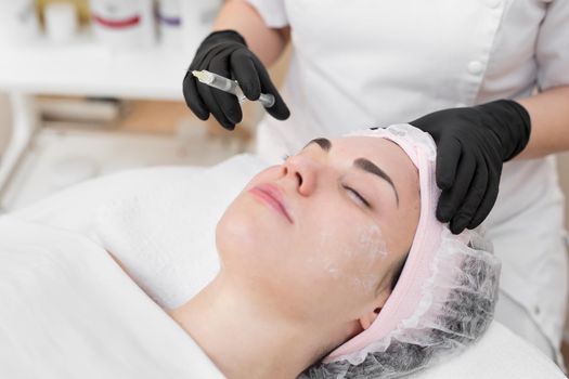 Woman face cosmetology treatment. Biorevitalization skin therapy. Injecting in medical salon. The procedure of biorevitalization in the area of eyes with a preparation with hyaluronic acid.