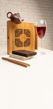 tea table with tea and a wine glass in which Sheng Pu'er tea is poured to demonstrate the color