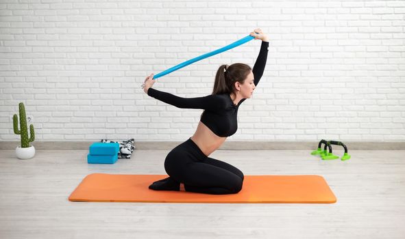 girl conducts a home workout stretching to strengthen her back