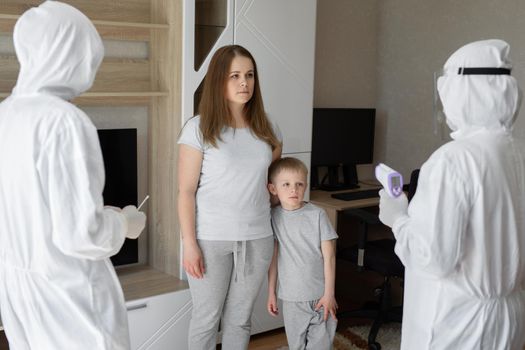 Doctors in protective suits at sick patients at home. Coronavirus, covid-19