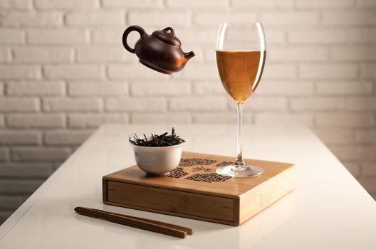 table with appliances and a wine glass in which tea is brewed