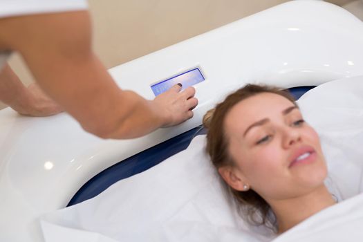Cosmetologist launches hydromassage in the Spa. Professional modern cosmetology. Body care. The process of the hydromassage bath in the cosmetology clinic.