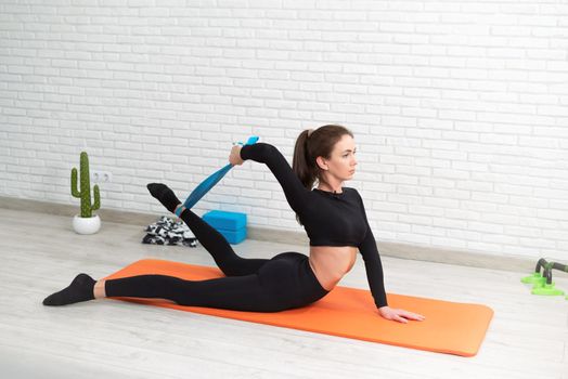 girl conducts a home workout stretching to strengthen her back