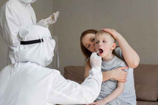 Doctor takes a cotton bud from child s mouth to analyze the saliva, mucous membrane for DNA tests, COVID-19, to determine or presence of virus, SARS-CoV-2 epidemic, coronavirus concept