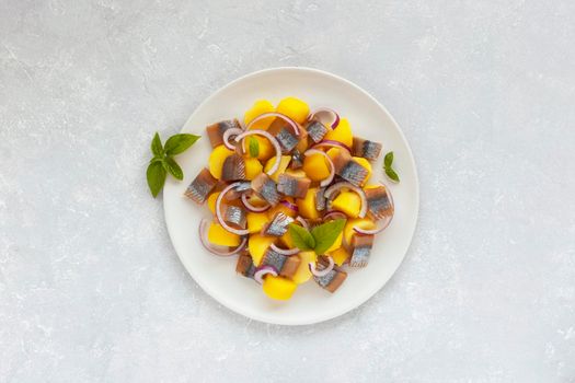 smoked hering, potatoes and onion salad decorated with basil, flatlay