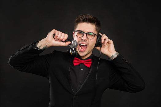DJ with headphones and microphone on a black background