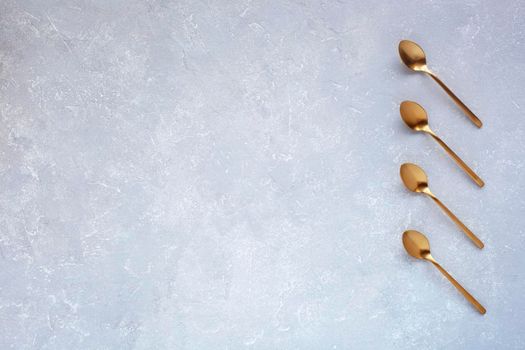 grey background with golden coffee spoons, top view, space for creating a list, plan, shedule