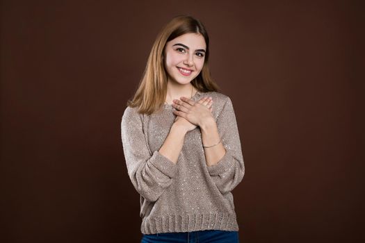 Happy beautiful female looks aside, wears warm sweater, dreams about date with handsome guy