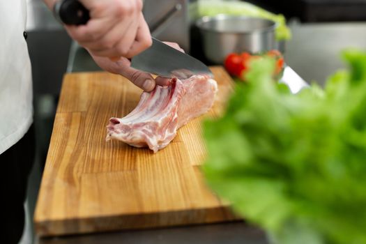 Chef cutting the meat on a wooden board