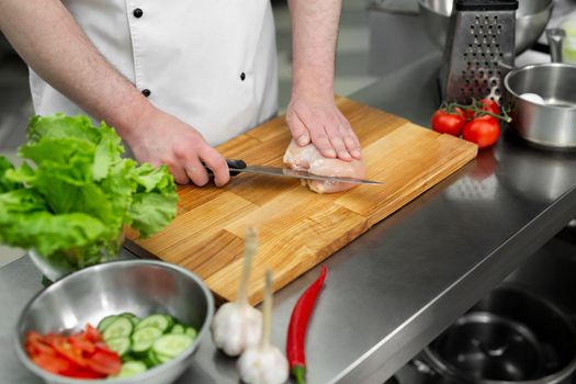 Raw chicken breast on a wooden board. Butchering chicken breast