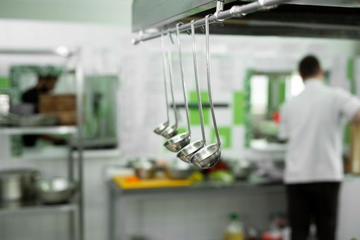 Shiny stainless steel buckets hang in the kitchen at the restaurant.