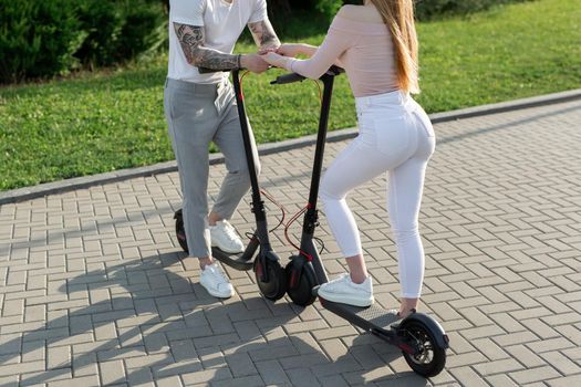 Young couple in the park on electric scooters