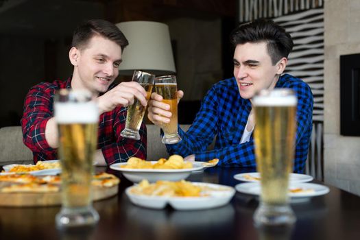 Celebrating success. Young cheerful people smile and celebrates success while resting in pub.
