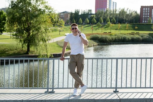 Beautiful man talking on the phone in the park