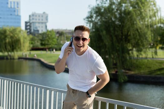 Beautiful man talking on the phone in the park