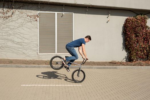 Teenage BMX rider is performing tricks in park
