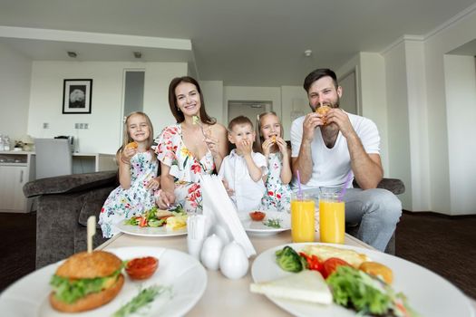 A young family eats breakfast in the hotel room