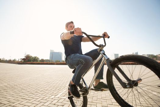 Teenage BMX rider is performing tricks in skatepark