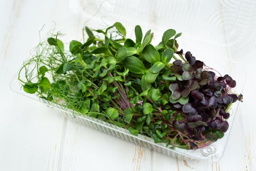 Microgreens , healthy food, organic food, super food. Box with fresh young sprouts on white wooden board.