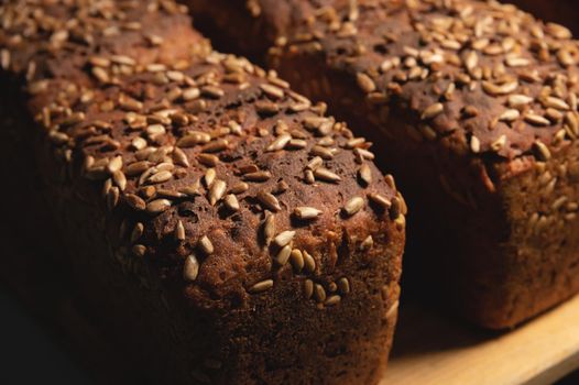 Close-up of rye black bread covered with sunflower seeds. Fresh hot bread. Healthy food. No Yeast.