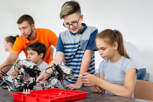 Kids working with teacher on their robot education project