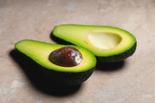 Fresh vegetables - Zutano avocado on table with a black background. Contrasting image of a tasty vegetable.