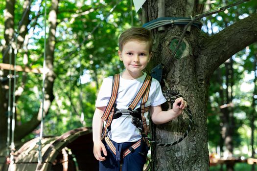 Little boy walking on an obstacle course. A rope tow.