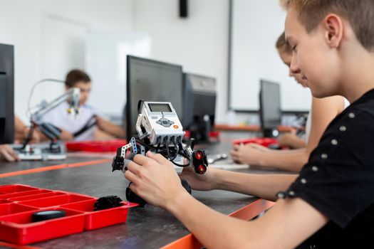 Concentrated teen child programming robot at class, stem education concept