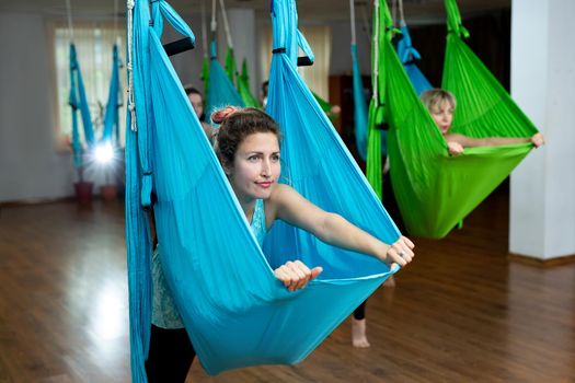 Beautiful athletic woman doing gravity yoga and stretching exercises. Healthy lifestyle concept