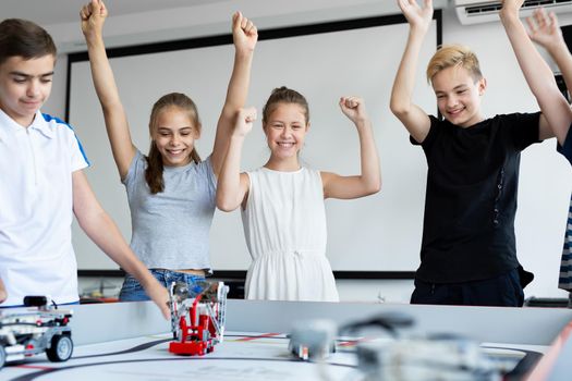 Children in robotics classes celebrate victory in robot battles