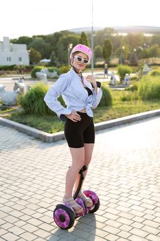 Portrait of a beautiful woman on a hoverboard or gyro scooter in the park