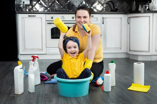 Happy mother and her daughter enjoy cleaning and having fun together.Mother and daughter having fun while cleaning