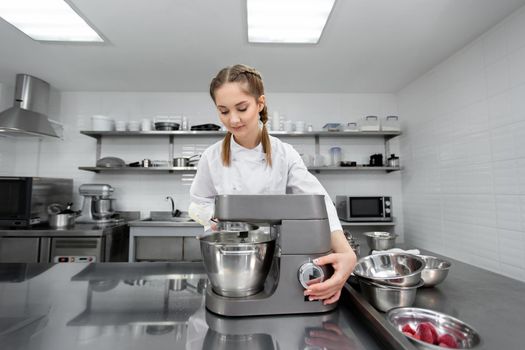 Pastry chef in the kitchen of the restaurant includes a mixer, food processor.