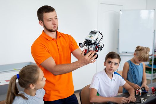 Kids working with teacher on their robot education project