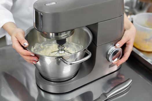 Pastry chef in the kitchen of the restaurant includes a mixer, food processor.