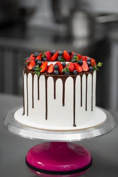 Cake with chocolate streaks and berries in the kitchen