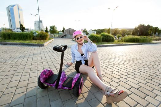 Portrait of a beautiful woman on a hoverboard or gyro scooter in the park