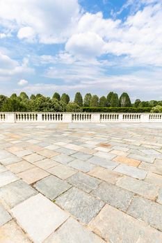 Exterior with old grey floor made of stone. Vintage textured pavement and blue sky in the background.