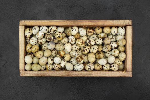 Lots of quail eggs in a wooden box on the background
