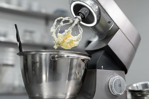 Butter with sugar on the Corolla of the kitchen machine, mixer.