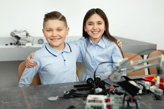 Group of children are playing with robots assembled from plastic parts.