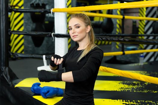 Photo of a focused girl in sportswear wearing boxing gloves during a workout