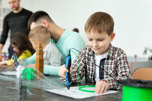 Child using 3D printing pen. Boy making new item. Creative, technology, leisure, education concept